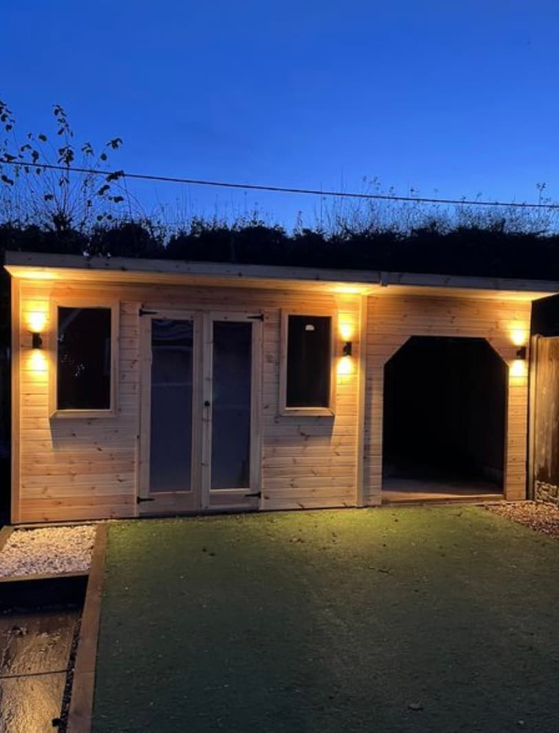 Timber garden building with warm exterior wall lights
