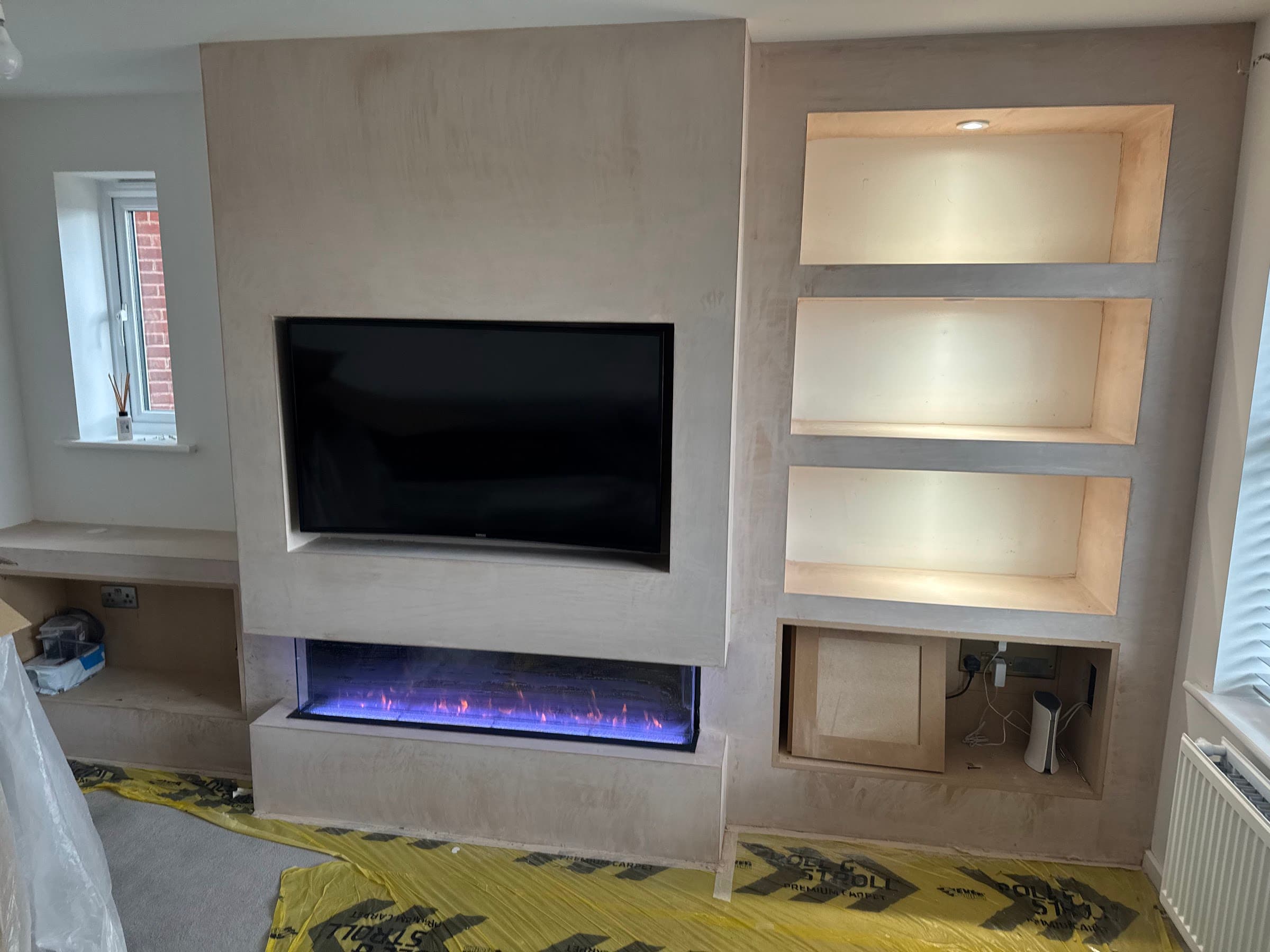 Media wall with illuminated display niches and electric fire